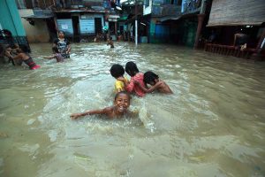 Sejumlah bocah bermain di halaman rumahnya yang tegenang air hujan saat terjadi banjir di Kampung Aur, Medan, kemarin. MTD/Dedis SJ