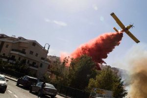 A firefighting plane in Haifa drops a slurry of water with thickener to stop it evaporating and iron oxide colouring to show where it has fallen. The Guardian/Photo: Jack Guez/AFP/Getty