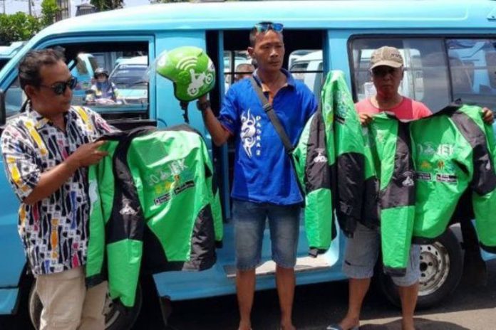 Awak angkot Salatiga menunjukkan helm dan jaket yang disita dari pengemudi Go-Jek, Senin (4/9/2017). (Tribun Jateng/Deni Setiawan)