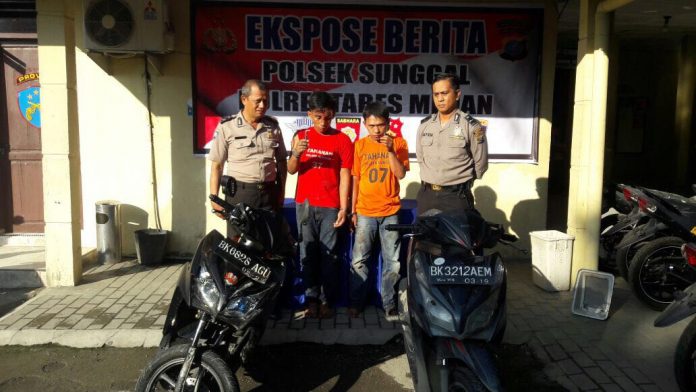 Petugas Polsek Sunggal berfoto dengan tersangka pencurian sepeda motor di Polsek Sunggal, Rabu (15/11/2017).