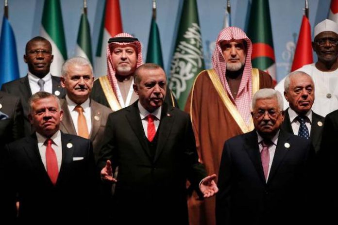Presiden Turki Recep Tayyip Erdogan (tengah) diapit oleh Raja Yordania Abdullah II (kiri) dan Presiden Palestina Mahmoud Abbas (kanan), dalam pertemuan KTT OKI, di Istanbul, Turki, Rabu (13/12/2017). (AP via The Telegraph).