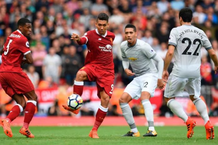 Disaksikan Georgionio Wijnaldum, Roberto Firmino mencoba melewat penjagaan Henrikh Mkhitaryan dan Chris Smalling saat Liverpool menjamu Manchester United di Anfield, Sabtu (14/10/2017).(AFP/Paul Ellis)