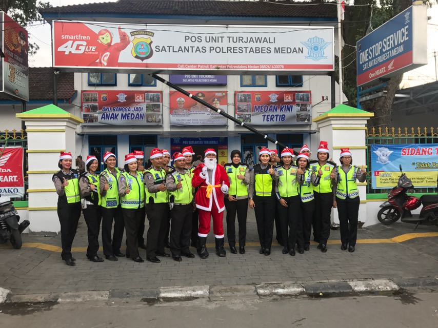 Personel Satlantas Polrestabes Medan saat foto bersama sebelum melakukan pembagian hadiah kepada para pengguna jalan yang melintas di seputaran Lapangan Merdeka, Sabtu (23/12/2017)