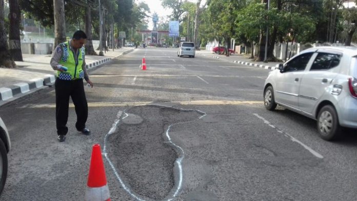 Polisi lalu lintas mengecat jalan berlubang di Imam Bonjol, Rabu (6/12/2017).